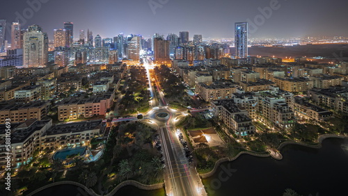 Fototapeta Naklejka Na Ścianę i Meble -  Panorama showing skyscrapers in Barsha Heights district and low rise buildings in Greens district aerial night timelapse.