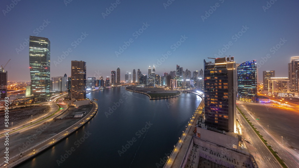 Cityscape of skyscrapers in Dubai Business Bay with water canal aerial day to night timelapse