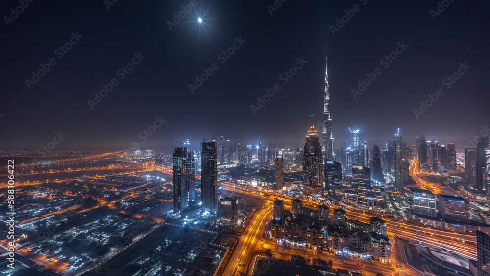 Aerial view of tallest towers in Dubai Downtown skyline and highway night timelapse.