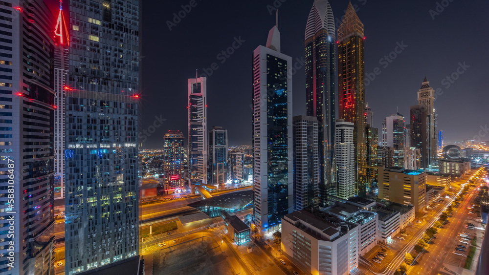 Aerial view of Dubai International Financial District with many skyscrapers all night timelapse.