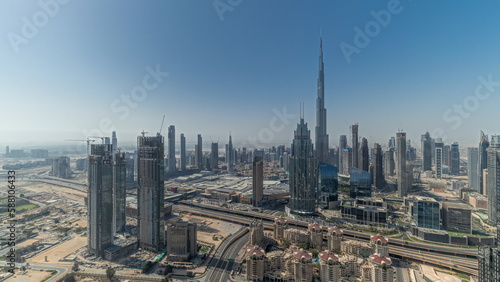 Panorama showing aerial view of tallest towers in Dubai Downtown skyline and highway timelapse.