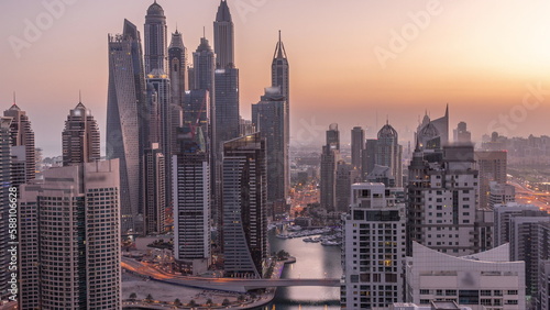 View of various skyscrapers in tallest recidential block in Dubai Marina aerial night to day timelapse