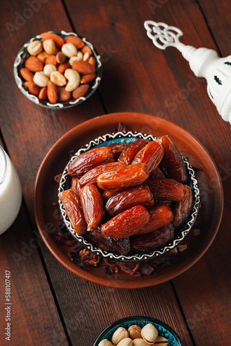 Ramadan Kareem and iftar muslim food. Pitted dates, nuts and milk on wooden boards. Traditional iftar food