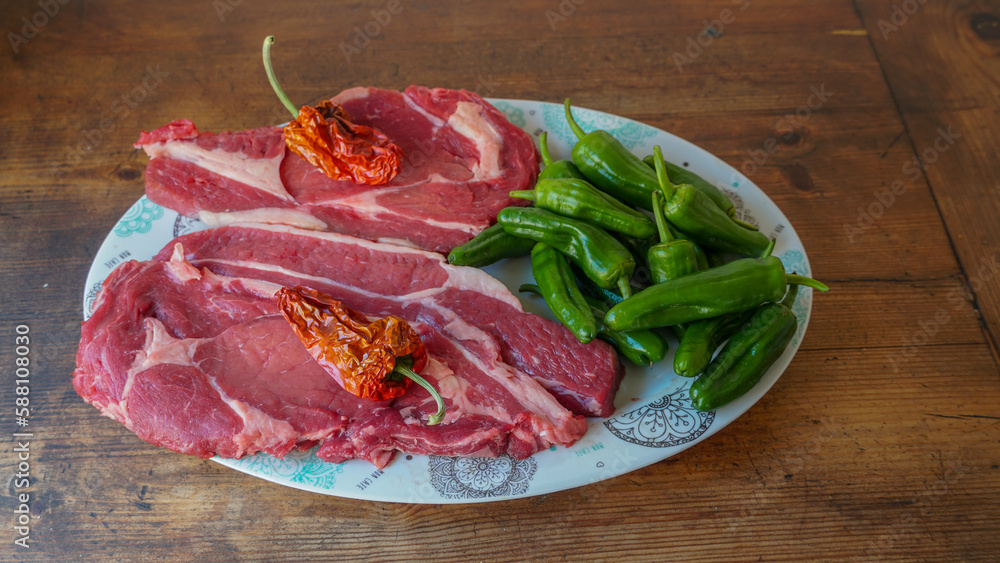 Chuletones en plato con pimientos de padron crudos. Chuletones en plato con pimientos de padron crudos.
