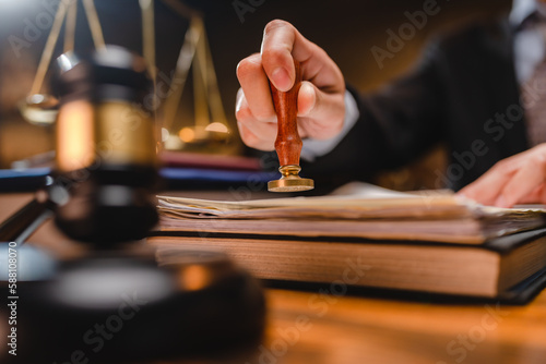 businessman or lawyer put a success stamp on legal deal contract in office, approved on certificate document public paper agreements at desk of notary or business people work to making a signs permit