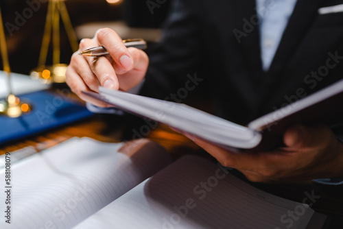 businessman or legal expert reviewing document reports at office workplace with computer laptop, professional lawyer reading and checking financial documents or insurance and sign a contract by pen
