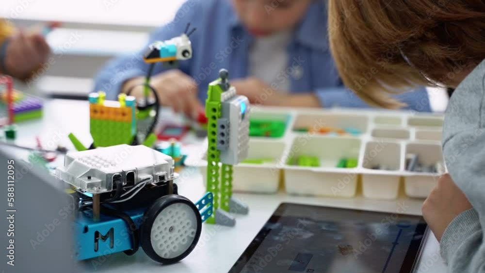 Robotics programming class. Children construct and code Robot. STEM ...