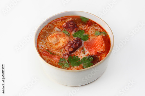 Soup with seafood and tomatoes. Soup with octopus, king prawns and red fish. Isolated object.White background.