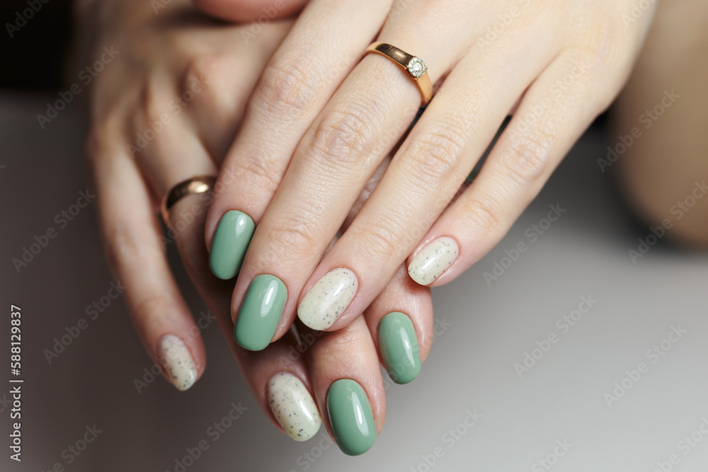 Female hands with nail design close-up. Beautiful female nails with green manicure