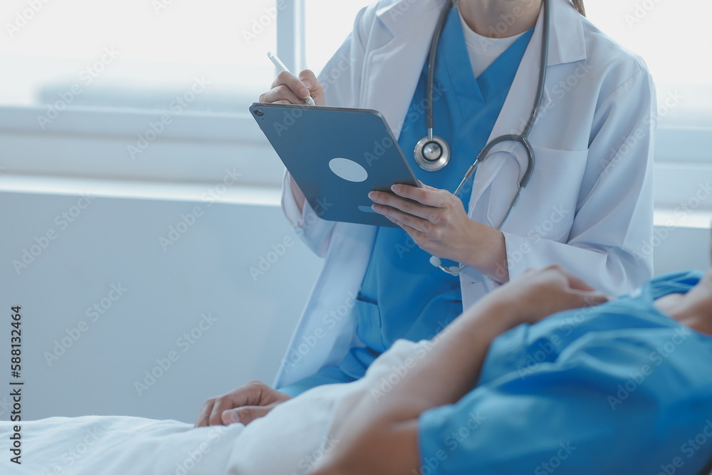 Women Asian doctors hold the patient hand and encourage and provide medical advice While checking the patient health in bed. Concept of Care and compassion, antenatal care, Threatened abortion Women Asian doctors hold the patient hand and encourage and provide medical advice While checking the patient health in bed. Concept of Care and compassion, antenatal care, Threatened abortion