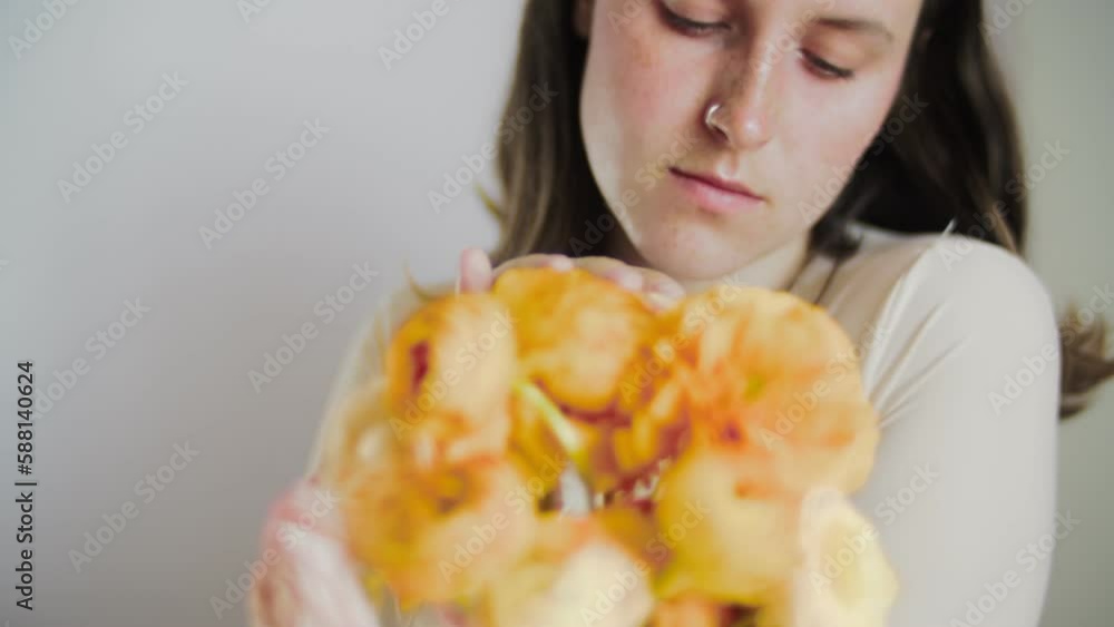 Female model posing with flowers. Close-up portrait 4K video. The young and attractive dark hair actor with dark eyes. Skincare concept video for social media. Female model posing with flowers. Close-up portrait 4K video. The young and attractive dark hair actor with dark eyes. Skincare concept video for social media.