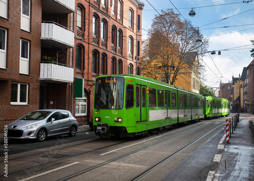 Hannover, Germany - October 14, 2022. A green train passing through a street in the city of Hannover
