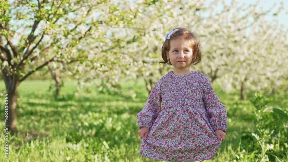 a pretty little girl in a violet dress in a spring garden a pretty little girl in a violet dress in a spring garden
