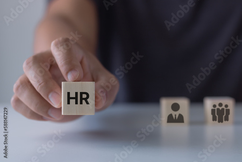 Human Resources Management (HR) Recruitment Employment Headhunting Concept. Man holding HR word on a wooden cube. Hand choosing a wooden person block from a set. Employment choice concept