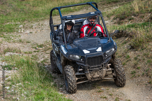 A man driving a quad ATV motorcycle through beautiful meadow landscapes