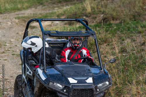 A man driving a quad ATV motorcycle through beautiful meadow landscapes