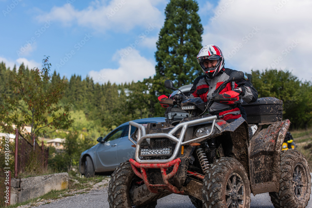 Adventurous driving of ATV motorbikes. A man drives a quad bike on