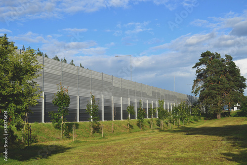 Noise-protective road barrier, which is an outdoor structure designed to protect people from noise. View of the acoustic panels from the protected living area.