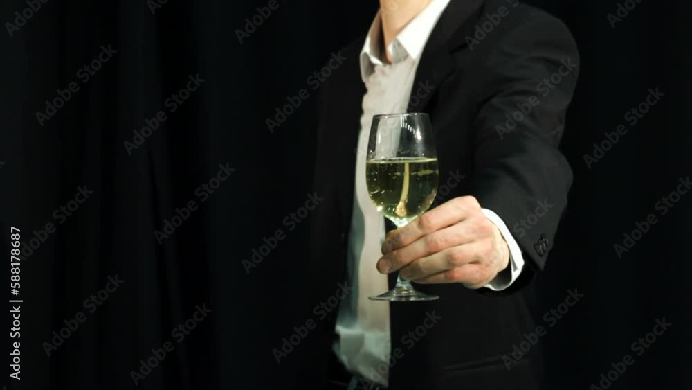 Businessman or man in formal suit adjusting hand with champagne glass to make a toast at the party Businessman or man in formal suit adjusting hand with champagne glass to make a toast at the party