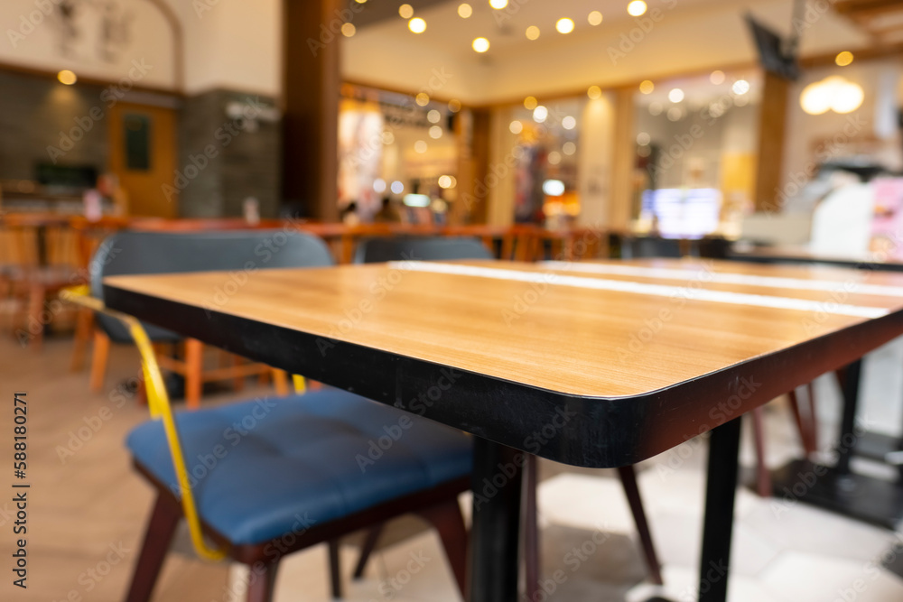Blurry cafe, restaurant or coffee shop background and perspective view of wooden table corner.