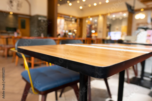 Blurry cafe  restaurant or coffee shop background and perspective view of wooden table corner.