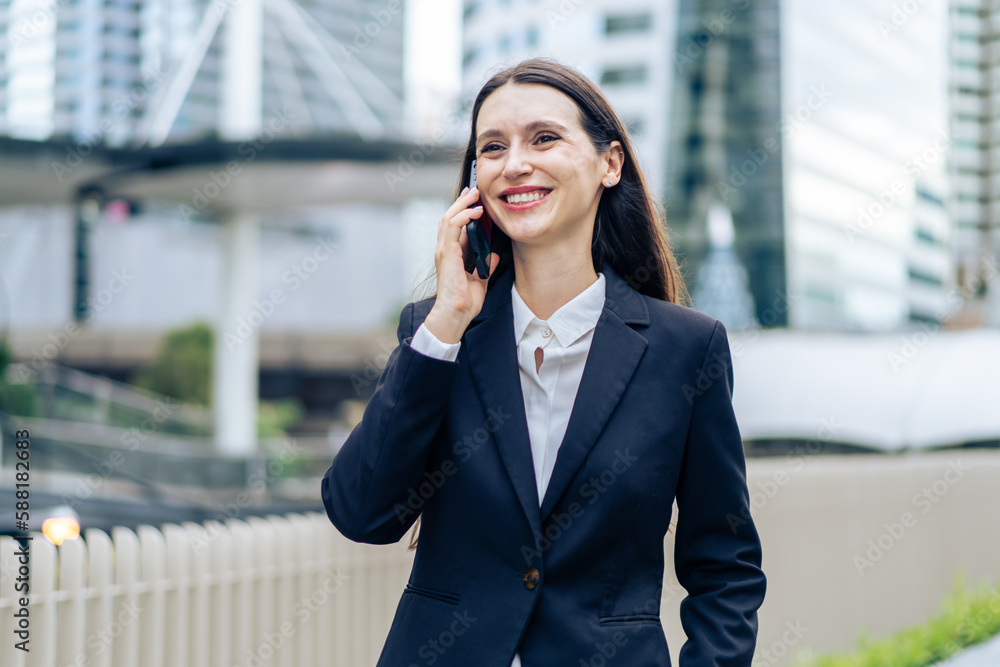 Caucasian young businesswoman talking on smartphone while walk in city. Caucasian young businesswoman talking on smartphone while walk in city.