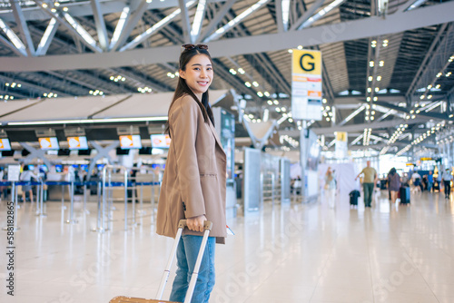 Portrait of Asian young girl walk in airport terminal to boarding gate.  © Kawee