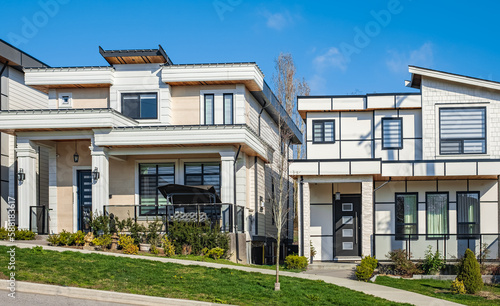 Fototapeta Naklejka Na Ścianę i Meble -  A perfect neighborhood. Houses in suburb at Spring in the north America. Real Estate Exterior Front House on a sunny day