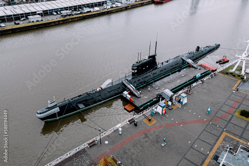 black submarine surfaced on the water in the city harbor. photo