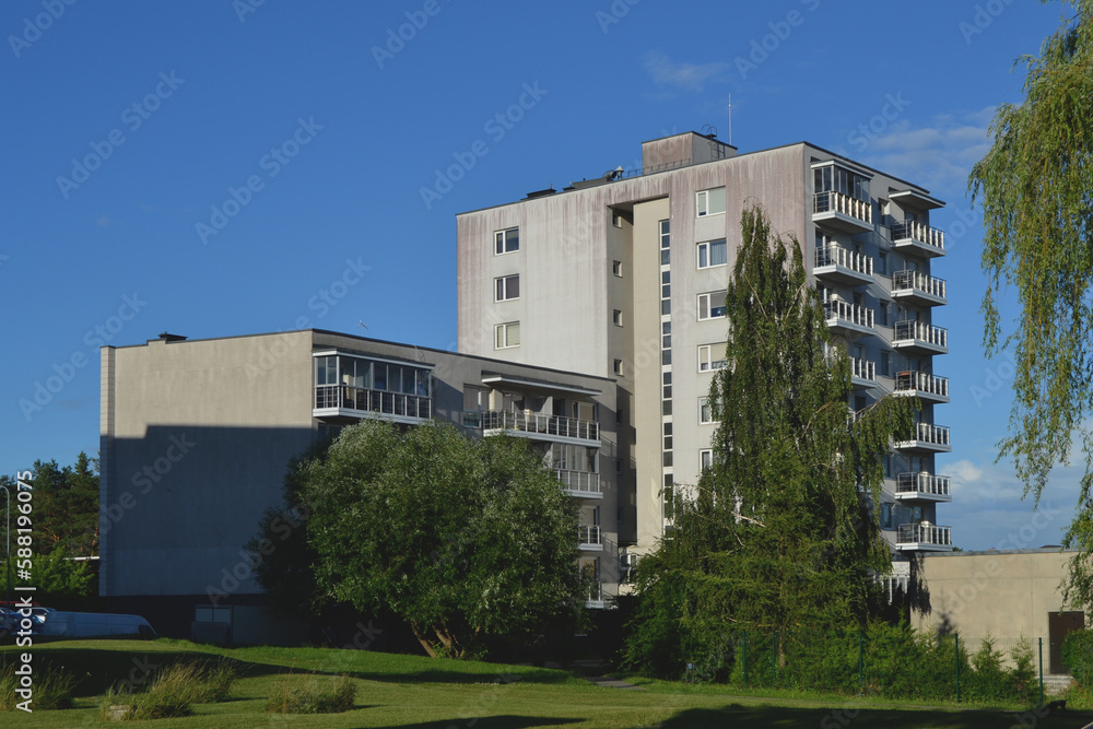 New modern block of flats in green area with blue sky
