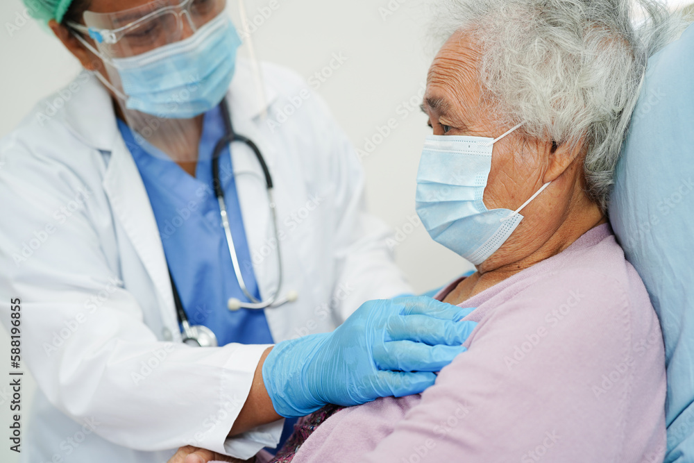Doctor in ppe user infrared thermometer to check temperature of asian elderly woman patient for safety to protect covid 19 virus. Doctor in ppe user infrared thermometer to check temperature of asian elderly woman patient for safety to protect covid 19 virus.