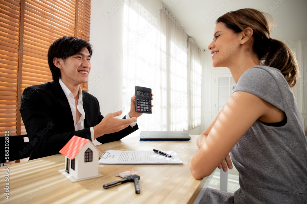 Young woman customer talking with agent about contract buying house and agreement of mortgage estate and calculate for planning in the home office, finance and investment, business concept. Young woman customer talking with agent about contract buying house and agreement of mortgage estate and calculate for planning in the home office, finance and investment, business concept.