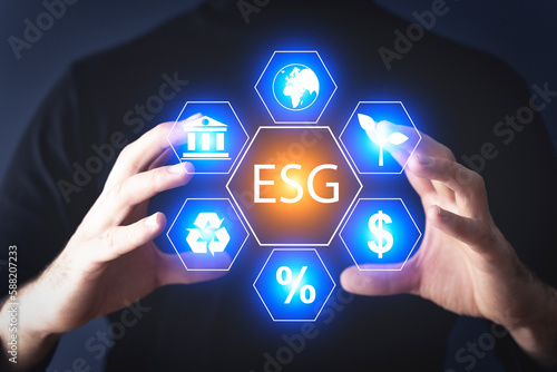 Global ESG technology concept. Man's hand presses a holographic button. Environmental, Social, and Corporate Governance idea.