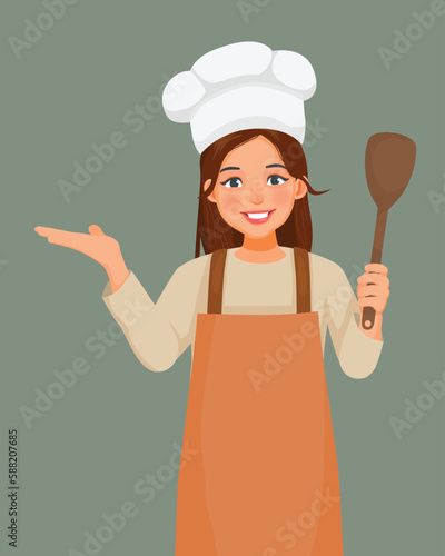 Young woman in chef hat and apron holding ladle showing hand for copy space
