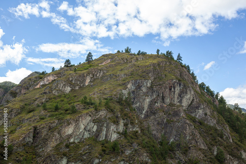 A large mountain with a sheer cliff close-up against the sky. Hiking tourism. Mountains of the Altai Mountains, Altai Republic © Анатолий Савицкий