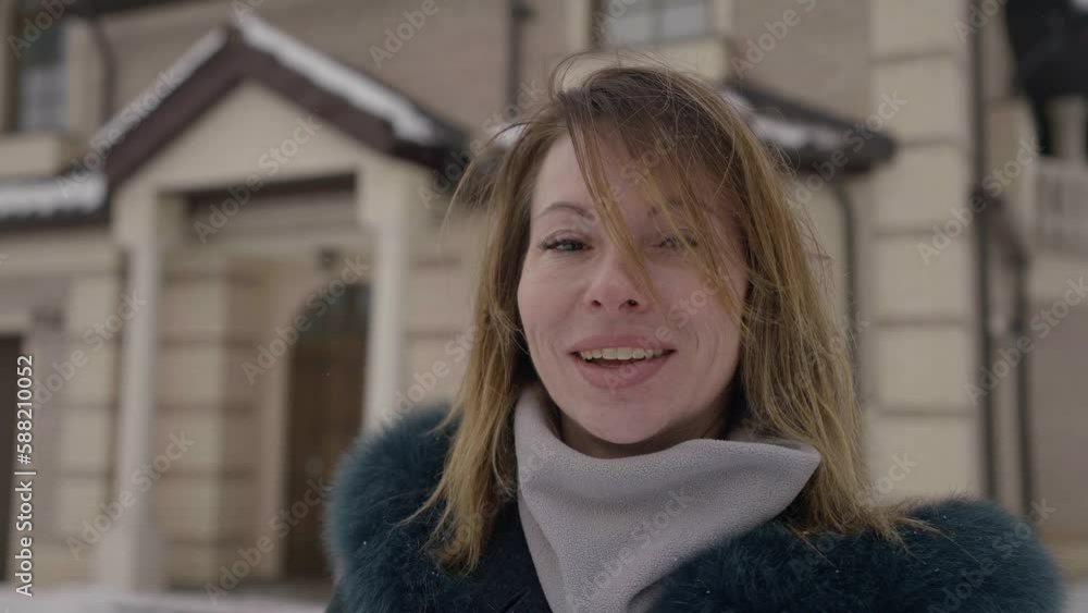 happy middle-aged woman looking at camera and smiling, female portrait outdoors in winter day happy middle-aged woman looking at camera and smiling, female portrait outdoors in winter day