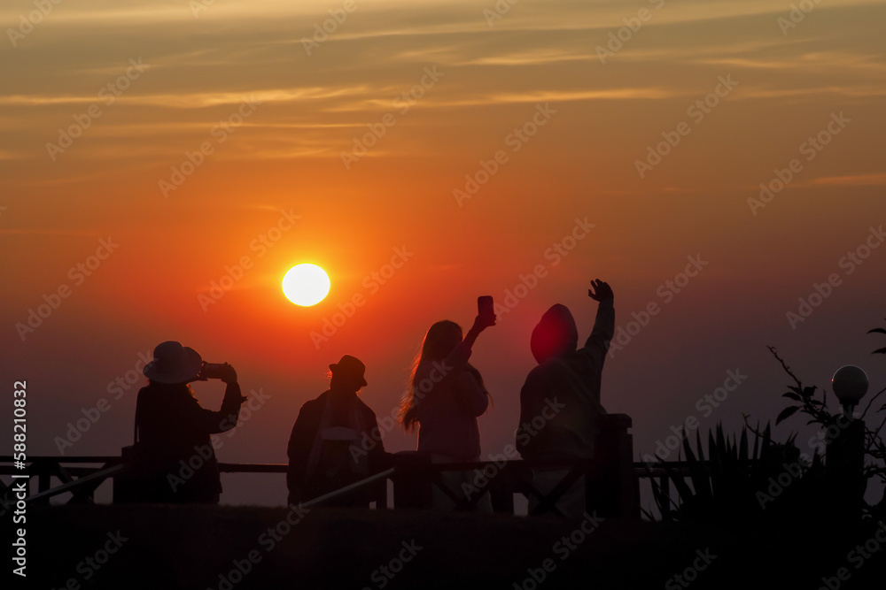 asians travel relax in the holiday.People stand looking at the sun in the morning. Stand up for sunrise on the Moutain