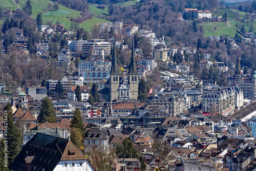 Aerial view of famous Swiss City of Luzern with medieval city and Church of St. Leodegard on a sunny spring day. Photo taken March 22nd, 2023, Lucerne, Switzerland.