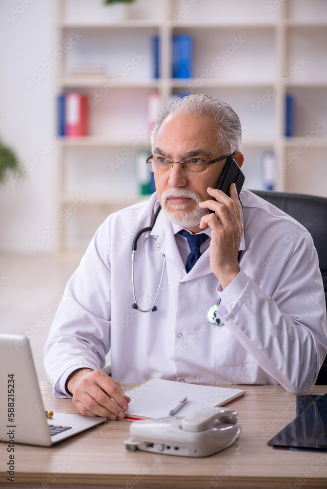 Old male doctor in telemedicine concept Old male doctor in telemedicine concept