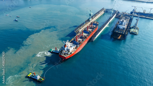 Tug boat Draging cargo container ship to dry dock concept maintenance service working in the sea. Insurance and Maintenance Cargo Ship concept. Freight Service maintenance Insurance