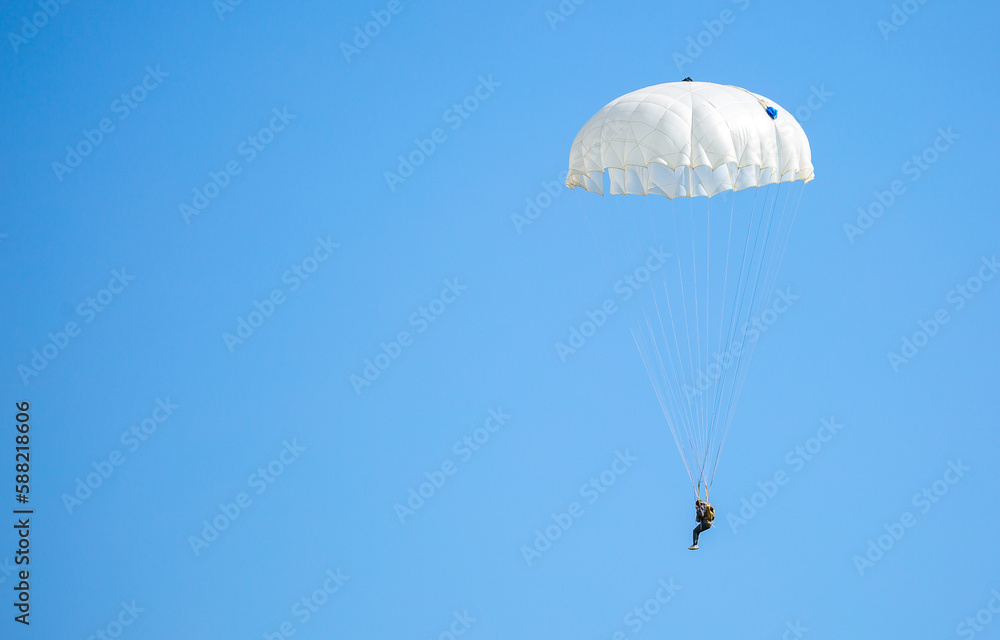 Skydiving. Flying parachutists against the background of the blue sky and mountains. Extreme sport and entertainment. Skydiving. Flying parachutists against the background of the blue sky and mountains. Extreme sport and entertainment.