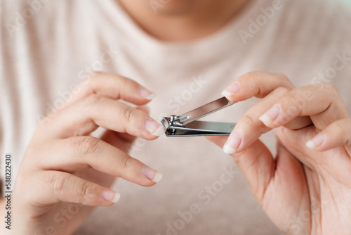 Woman cutting fingernails using nail clipper, Healthcare, Beauty Concept.