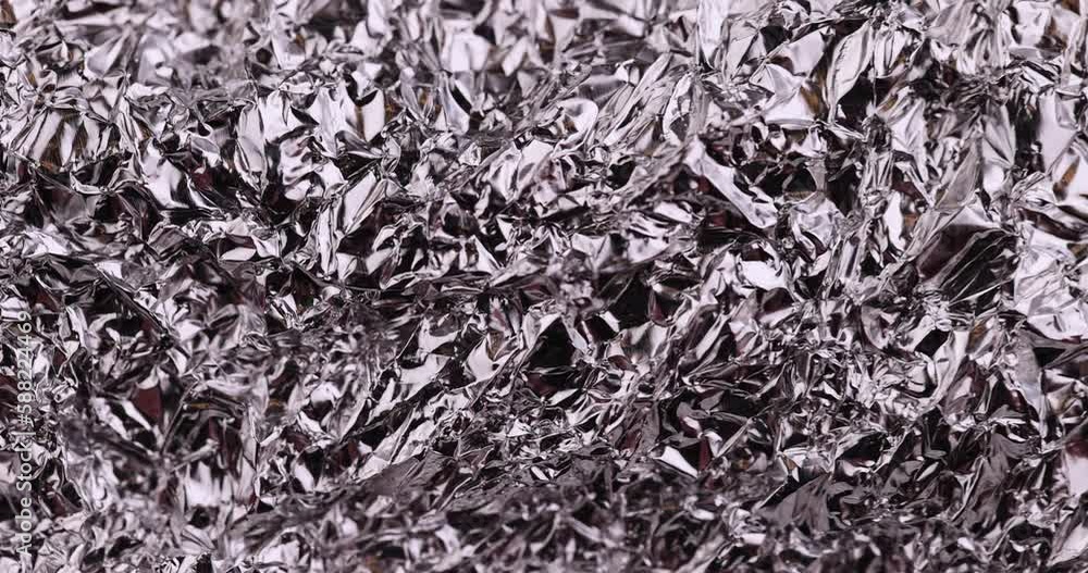 move old used crumpled aluminum foil, close-up of a foil structure with crumbs from food move old used crumpled aluminum foil, close-up of a foil structure with crumbs from food