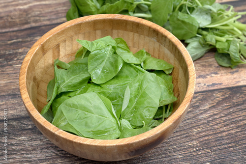 fresh spinach in a wooden bowl