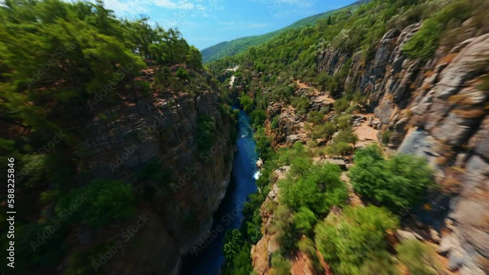 FPV sports drone extreme flight high cliff rocky texture over speed movement natural mountain river water flow narrow gorge. FPV sports drone extreme flight high cliff rocky texture over speed movement natural mountain river water flow narrow gorge.