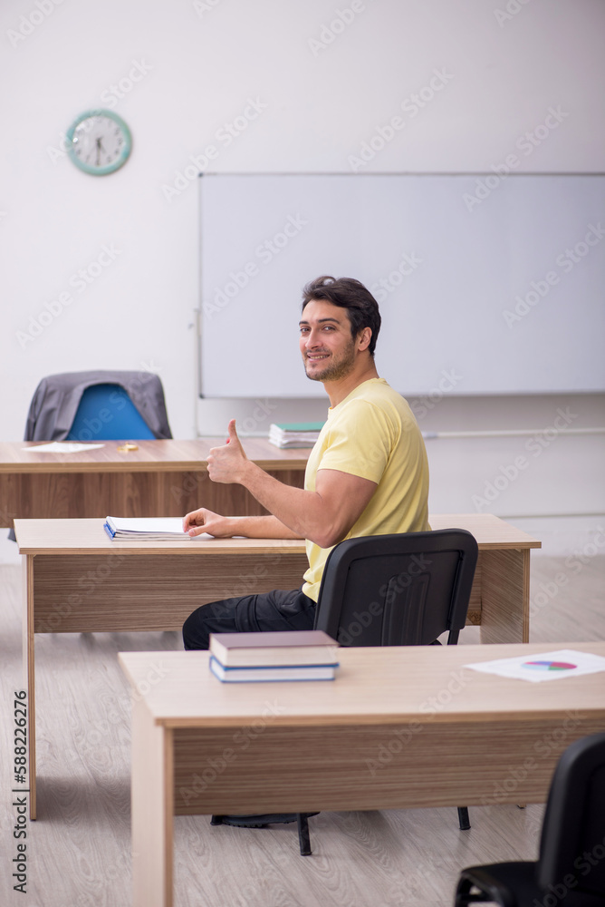 Young male student teacher sitting in the classroom Young male student teacher sitting in the classroom