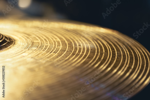 Drum cymbal close-up on a dark background.