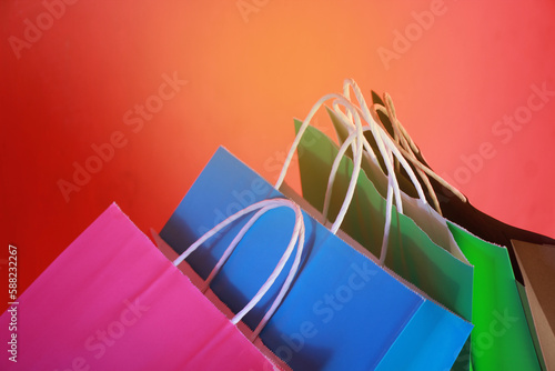 Colorful paper shopping bags on an orange background