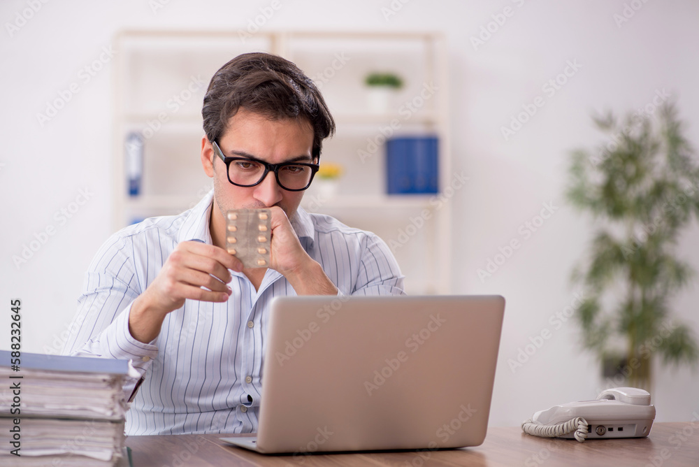 Young male employee feeling bad at workplace Young male employee feeling bad at workplace