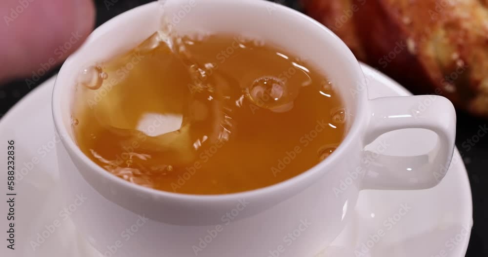 Sugar in hot green tea melts and forms a large number of bubbles, air bubbles from refined sugar in a mug of hot green tea Sugar in hot green tea melts and forms a large number of bubbles, air bubbles from refined sugar in a mug of hot green tea